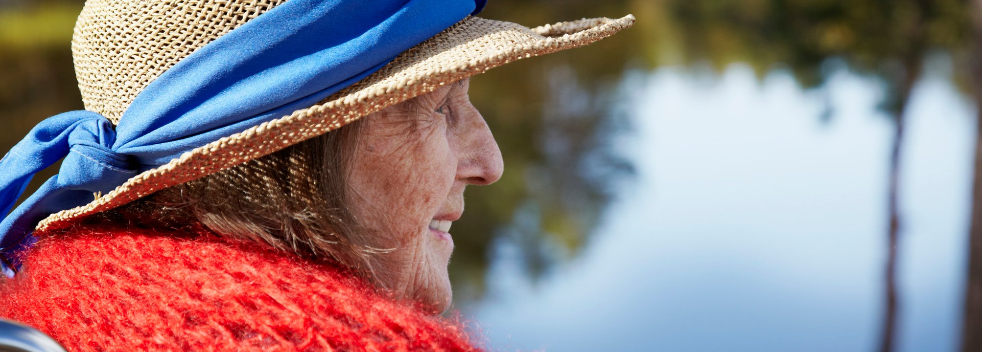 En äldre kvinna tittar ut mot vattendrag. 